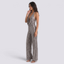 Essyro silver sequin halter neck jumpsuit with wide legs and open back worn by a model on a white background
