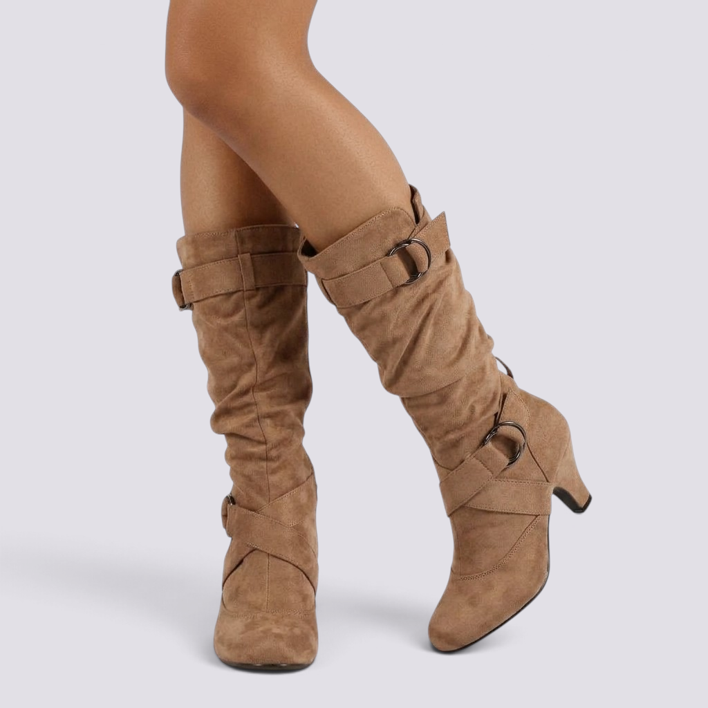 Essyro slouch boots in tan faux suede with mid-curved heels, round toes, and decorative side buckle straps.
