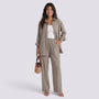Essyro two-piece set featuring a taupe loose-fit long-sleeve shirt and matching wide-leg trousers on a smiling model.