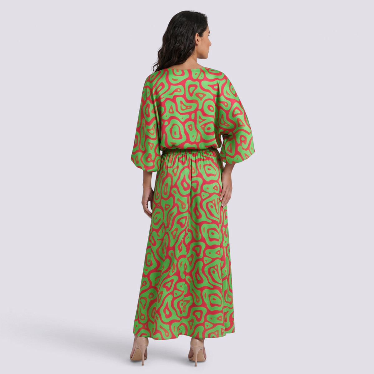Back view of a woman wearing an Essyro two-piece set with a green and pink abstract print, long skirt, and top.