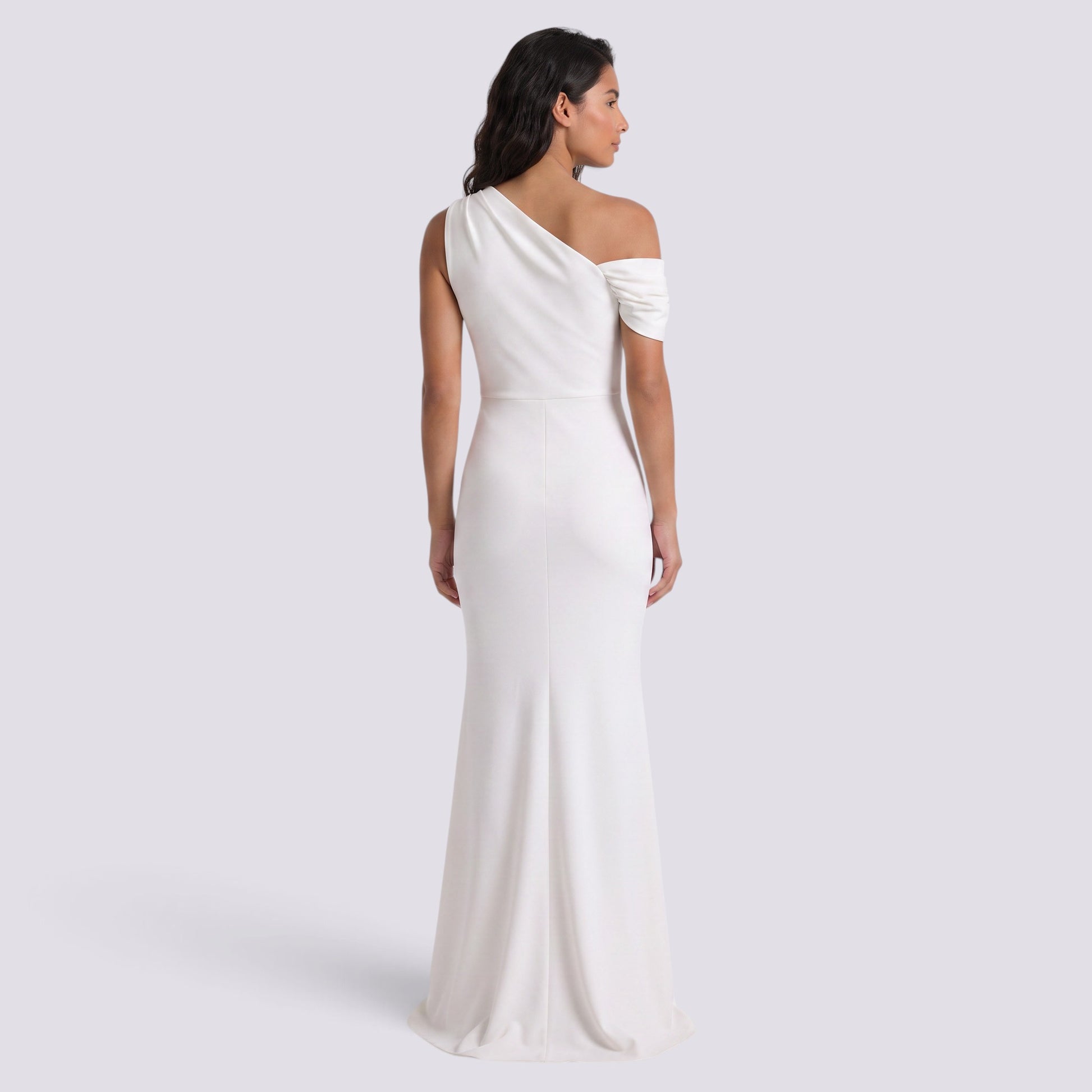 Essyro white floor-length mermaid gown with an asymmetric one-shoulder neckline and draped sleeve detail.
