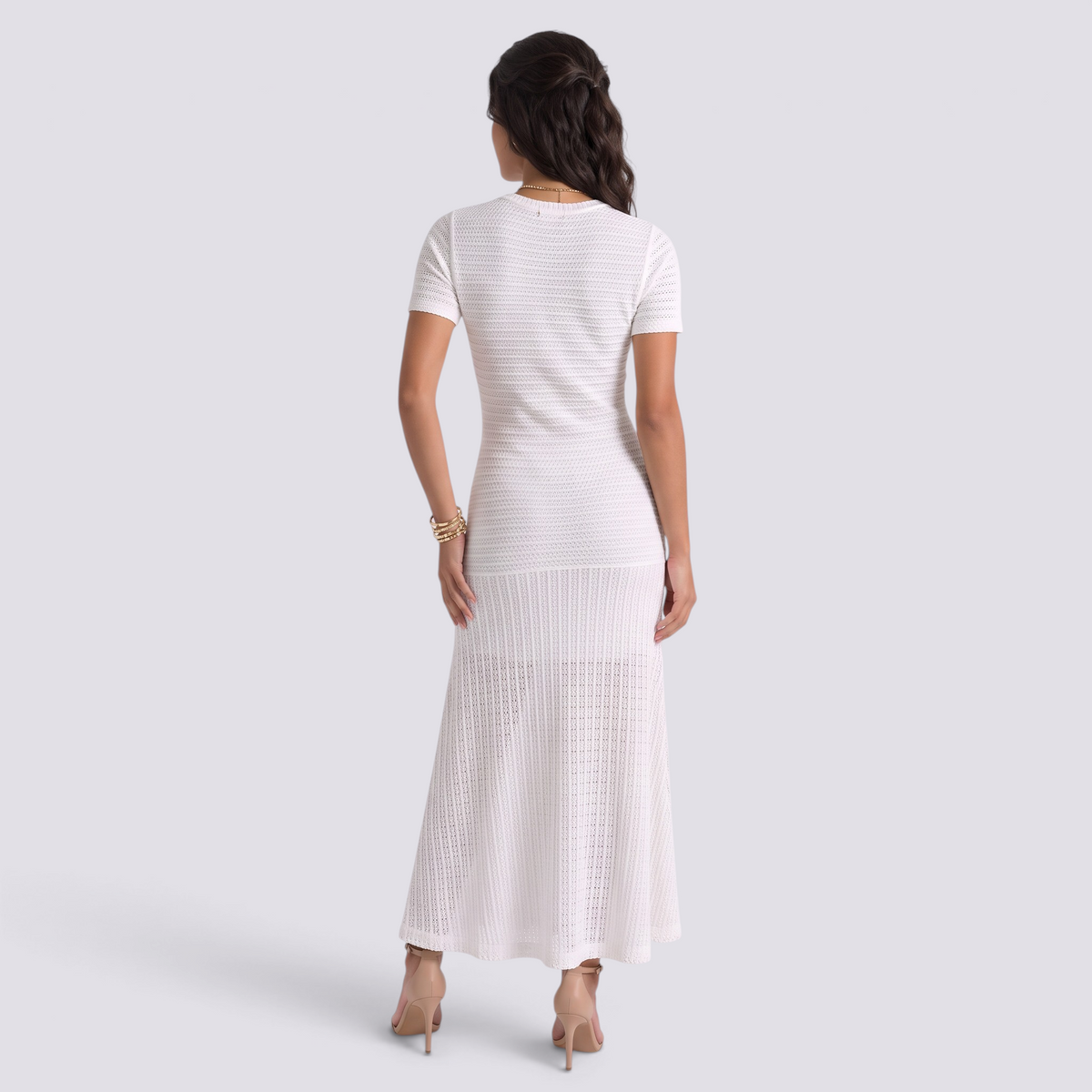 Essyro white ribbed knit maxi dress with short sleeves and flared hem seen from the back on a model