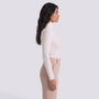 Model wearing an Essyro white ribbed turtleneck sweater with long sleeves and a fitted silhouette, side view.