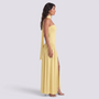 Essyro yellow floor-length halter neck dress with an asymmetric draped skirt and side slit worn by a model