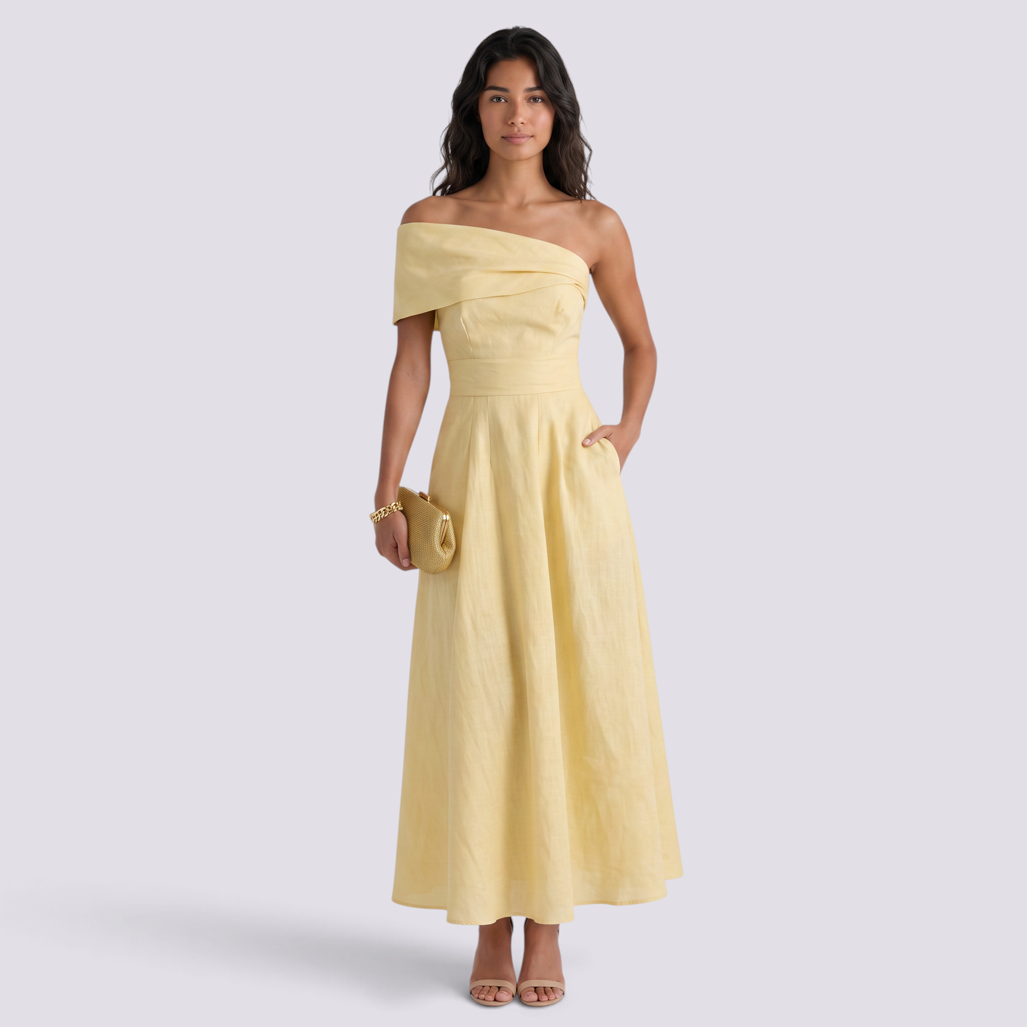 Essyro elegant yellow off-the-shoulder maxi dress with a fluid silhouette worn by a model with a gold clutch