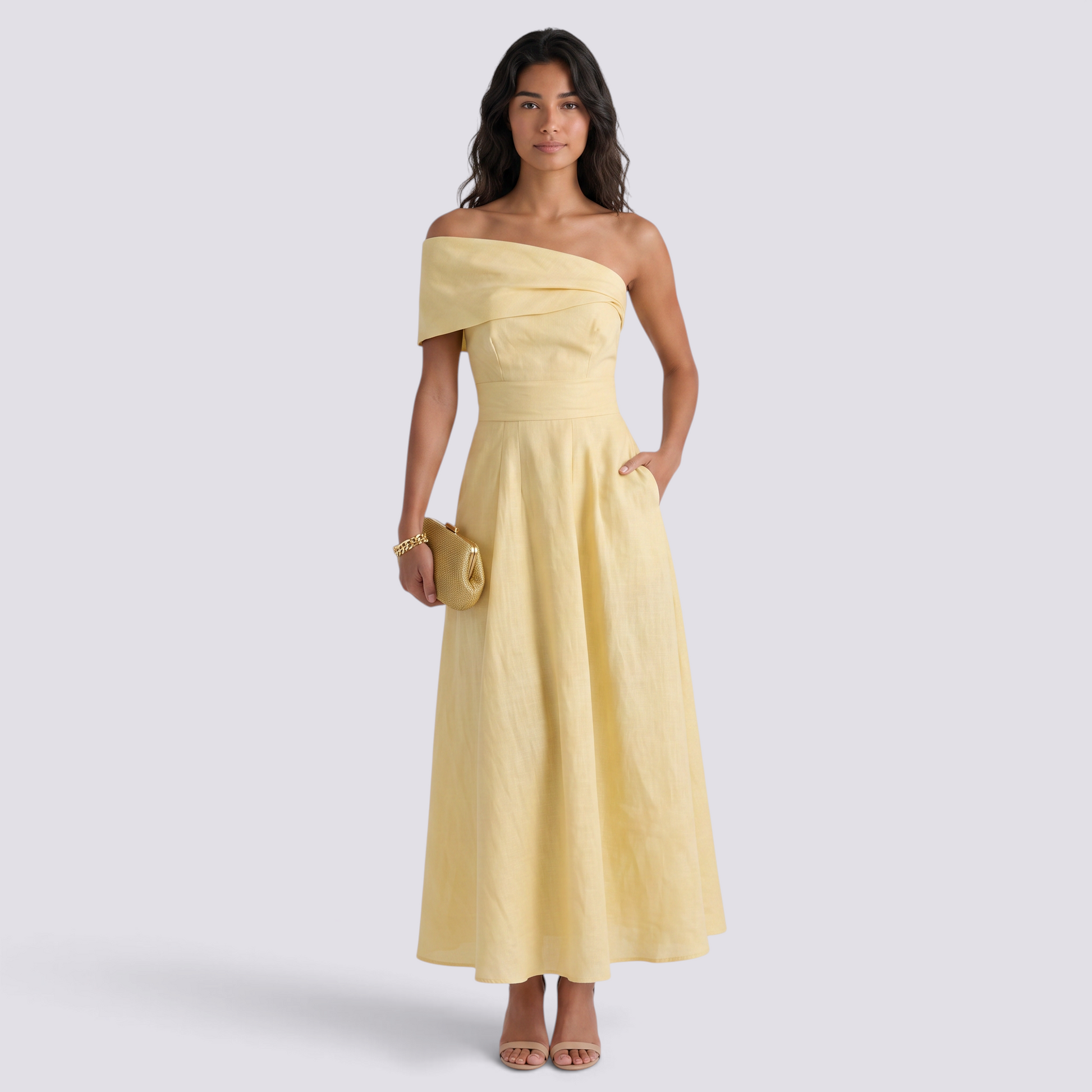Essyro elegant yellow off-the-shoulder maxi dress with a fluid silhouette worn by a model with a gold clutch