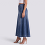 Mujer con falda vaquera larga evasé en azul oscuro con bajo deshilachado, vista lateral