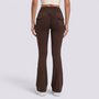 Mujer con leggings acampanados con bolsillos en marrón chocolate, vista trasera con bolsillos