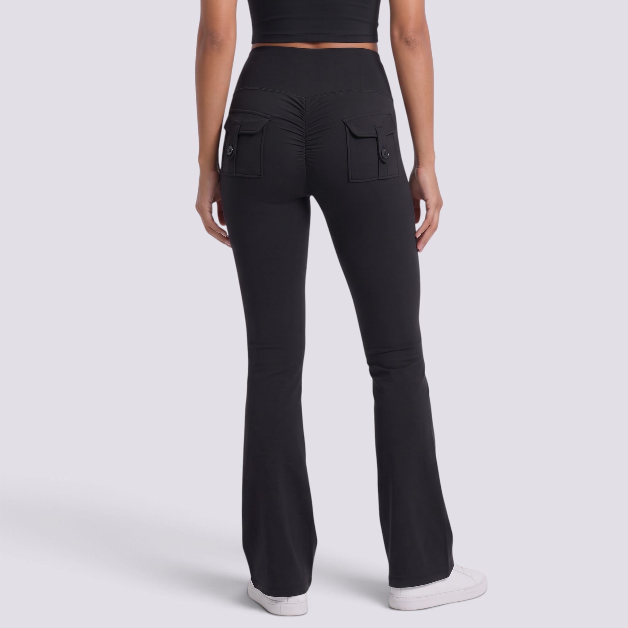Mujer con leggings acampanados con bolsillos en negro, vista trasera con bolsillos