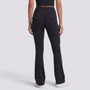 Mujer con leggings acampanados con bolsillos en negro, vista trasera con bolsillos