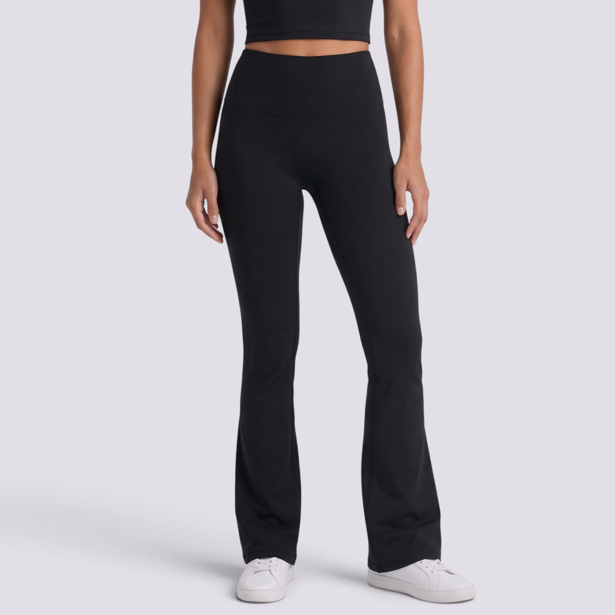 Mujer con leggings acampanados con bolsillos en negro, vista frontal
