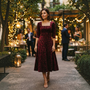 Essyro burgundy velvet midi dress with floral jacquard pattern, square neckline, and A-line skirt worn at an event.
