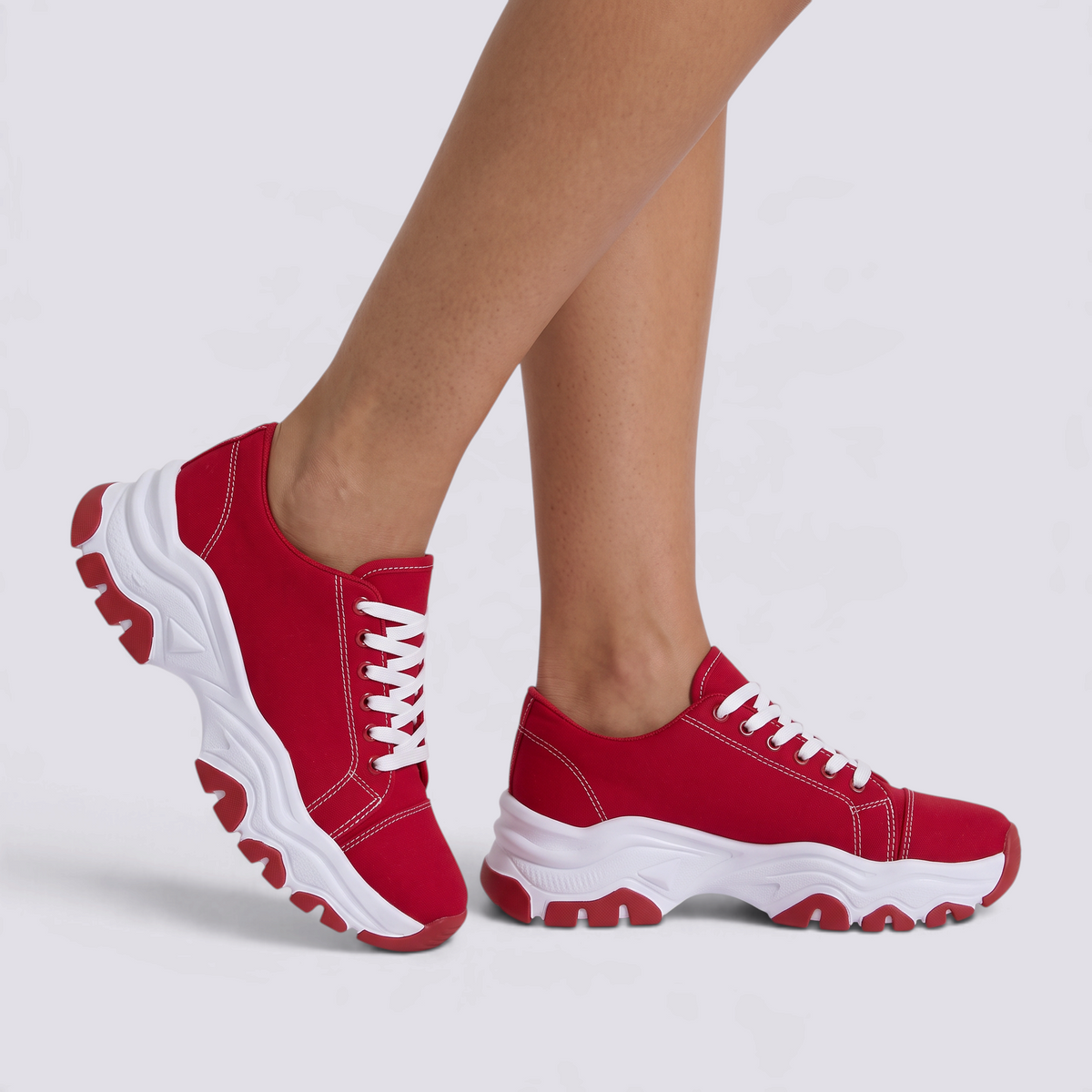 Zapatillas deportivas de mujer rojas con suela ondulada y cordones, vista lateral