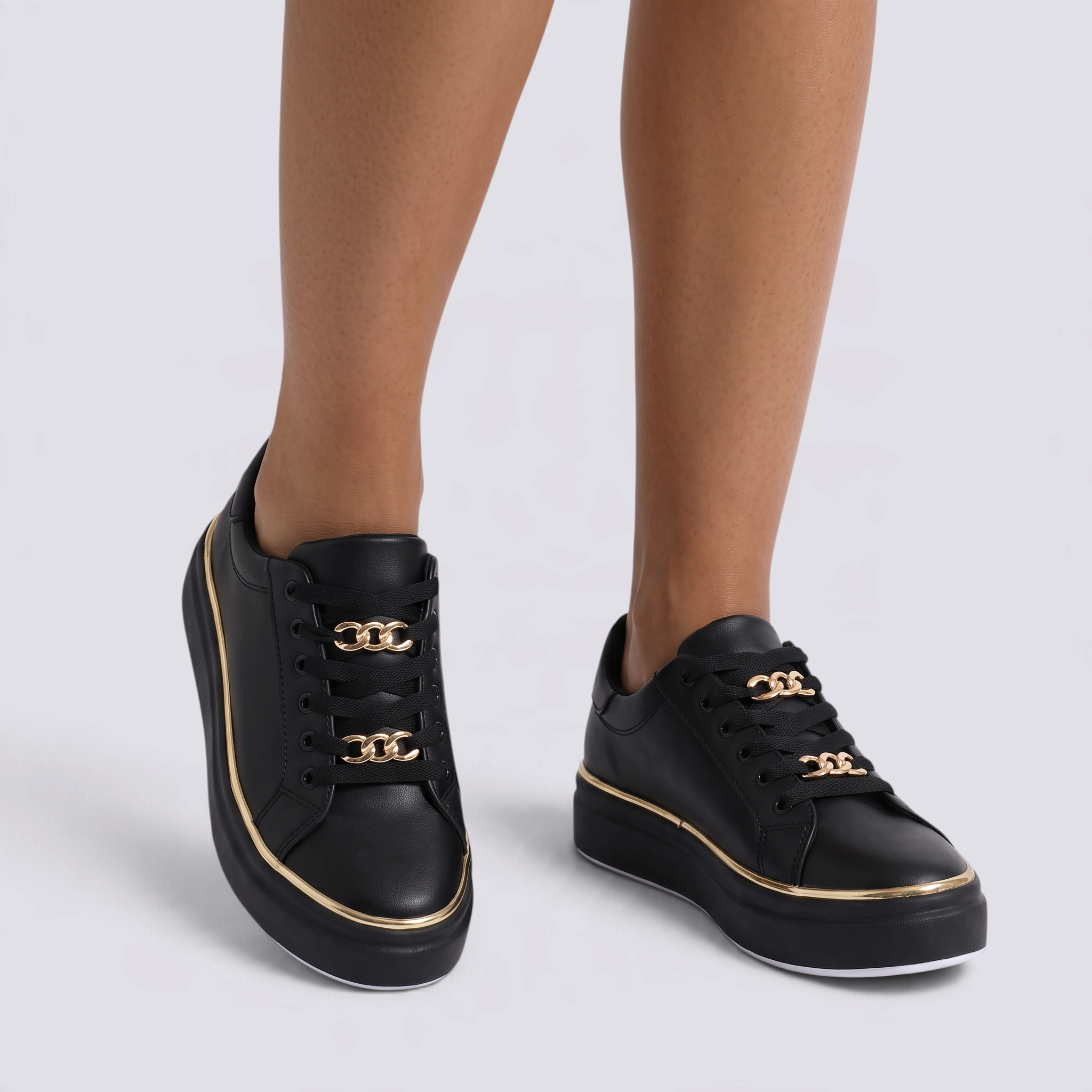 Zapatillas mujer negras con plataforma, ribete dorado y cadenas doradas, vista frontal