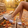 Zapatillas deportivas chunky mujer color champán con suela de plataforma en un banco de parque en otoño