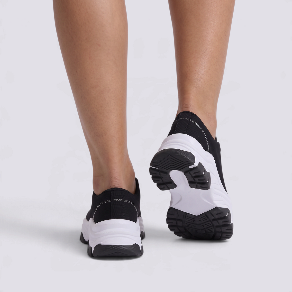Zapatillas deportivas de mujer negras con suela ondulada y cordones, vista trasera