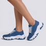 Zapatillas deportivas de mujer azules con suela ondulada y cordones, vista lateral