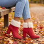 Botines rojos con borde de pelo crema en un parque de otoño