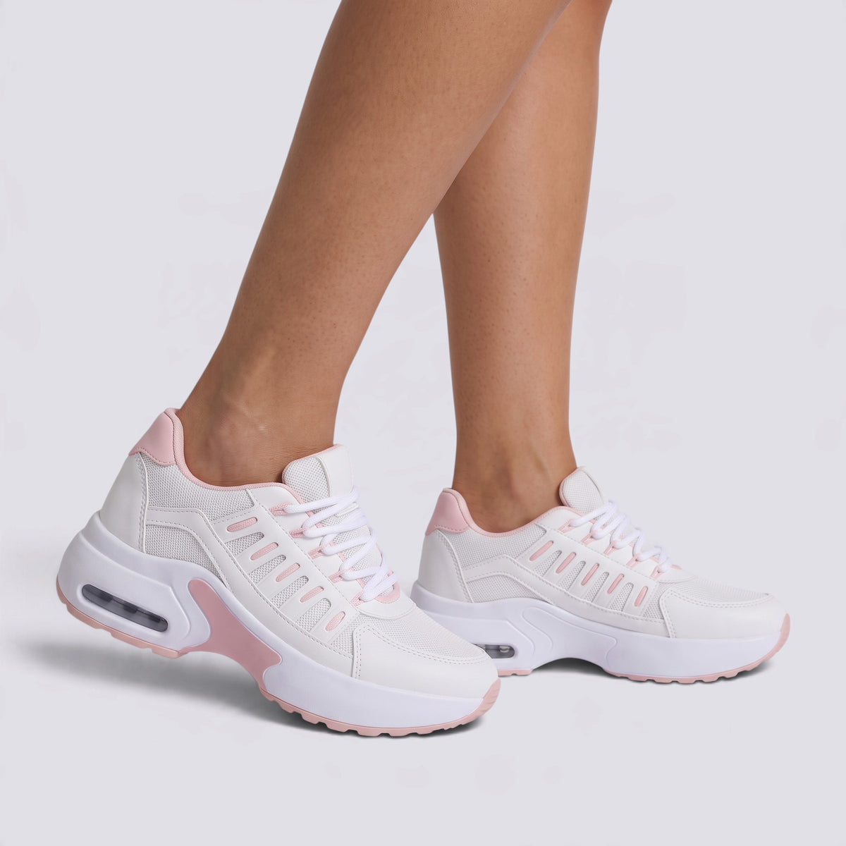 Zapatillas deportivas chunky mujer blancas con detalles rosa pálido, suela de plataforma y paneles calados, vista lateral
