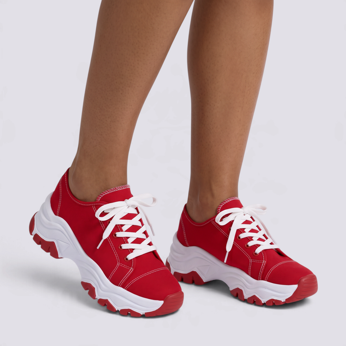 Zapatillas deportivas de mujer rojas con suela ondulada y cordones, vista frontal