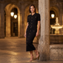 Conjunto punto mujer polo y falda con botones, negro, look de noche en una plaza con soportales