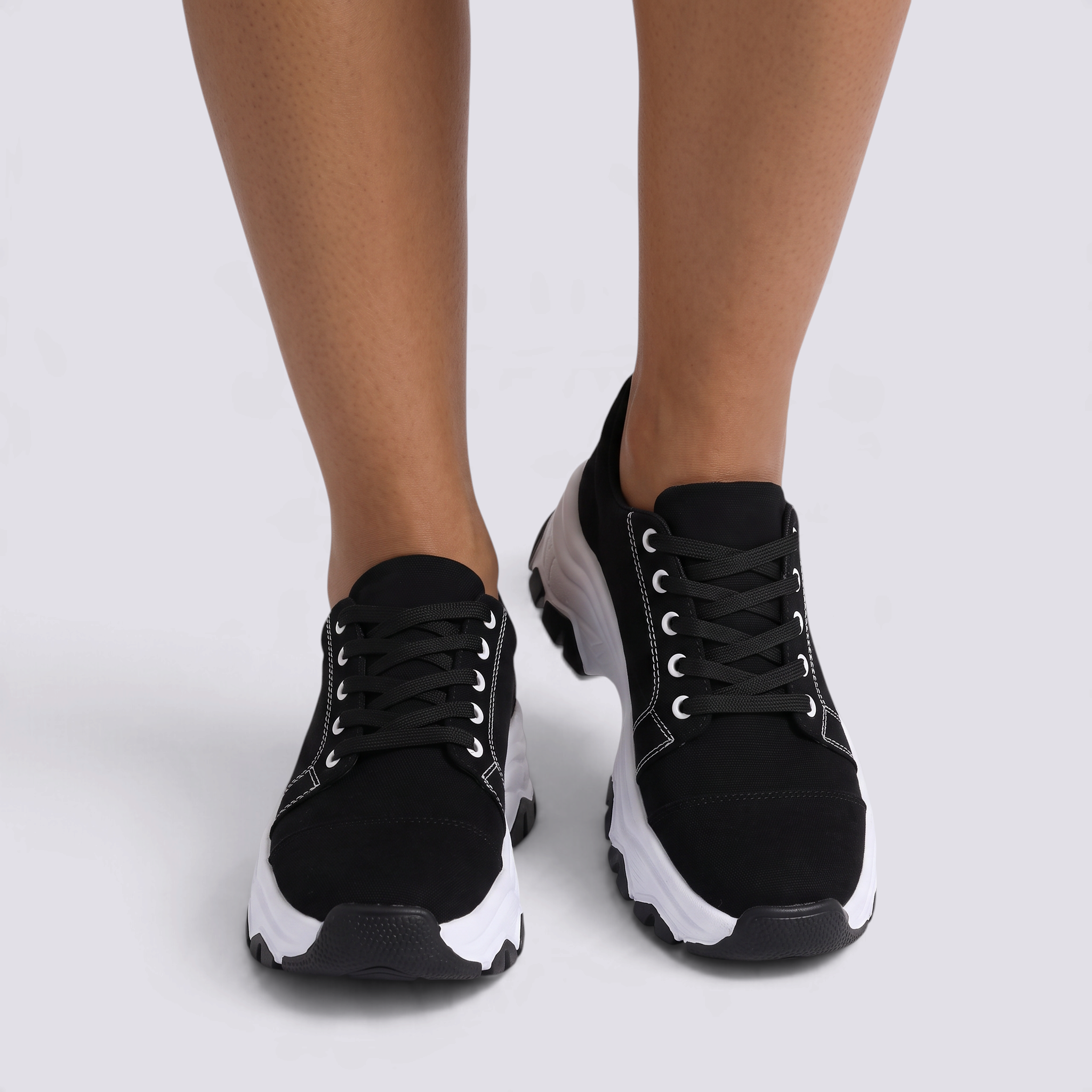Zapatillas deportivas de mujer negras con suela ondulada y cordones, vista frontal