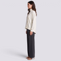 Top de mujer cuello alto con botones y bajo asimétrico en blanco marfil, vista lateral