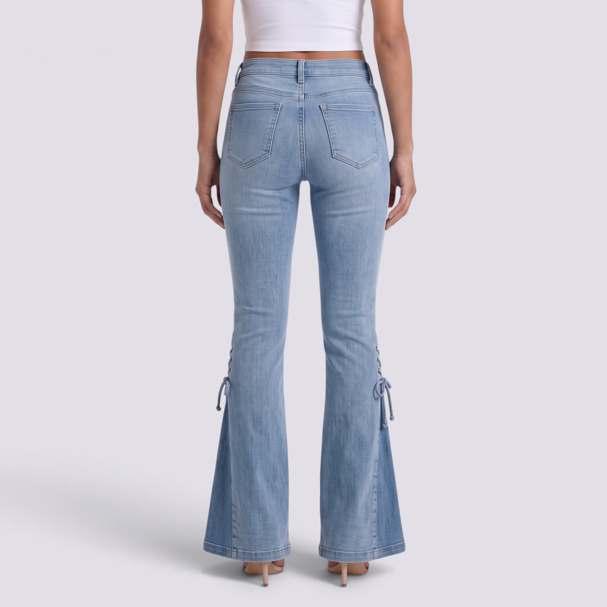 Mujer con vaqueros flare azul claro con cordones laterales, vista trasera