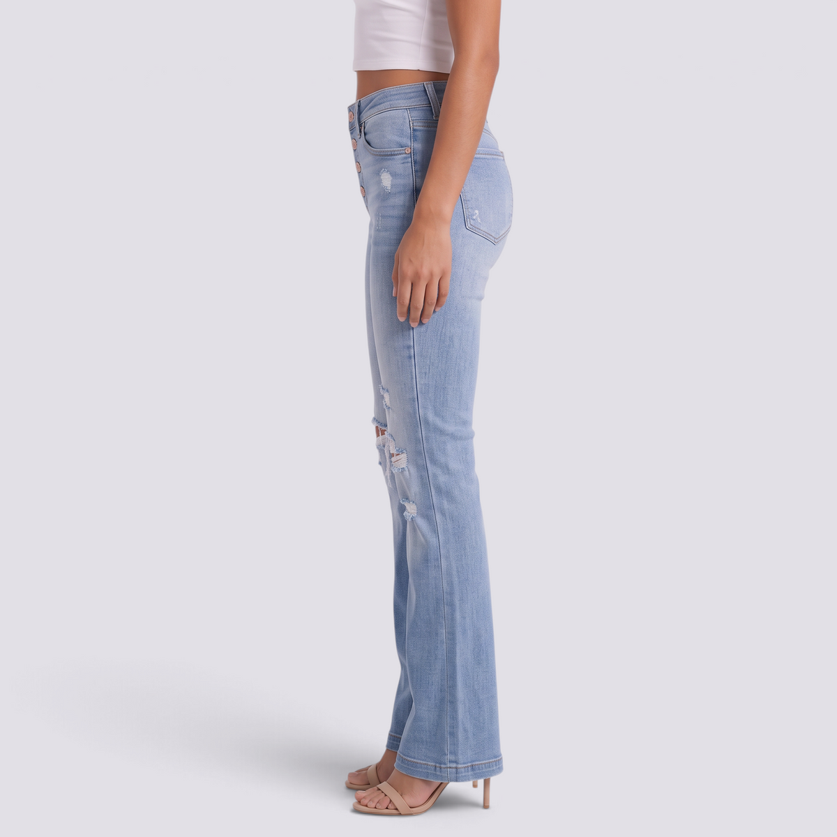 Vaqueros rotos de mujer con campana y efecto desgastado en azul claro, vista lateral