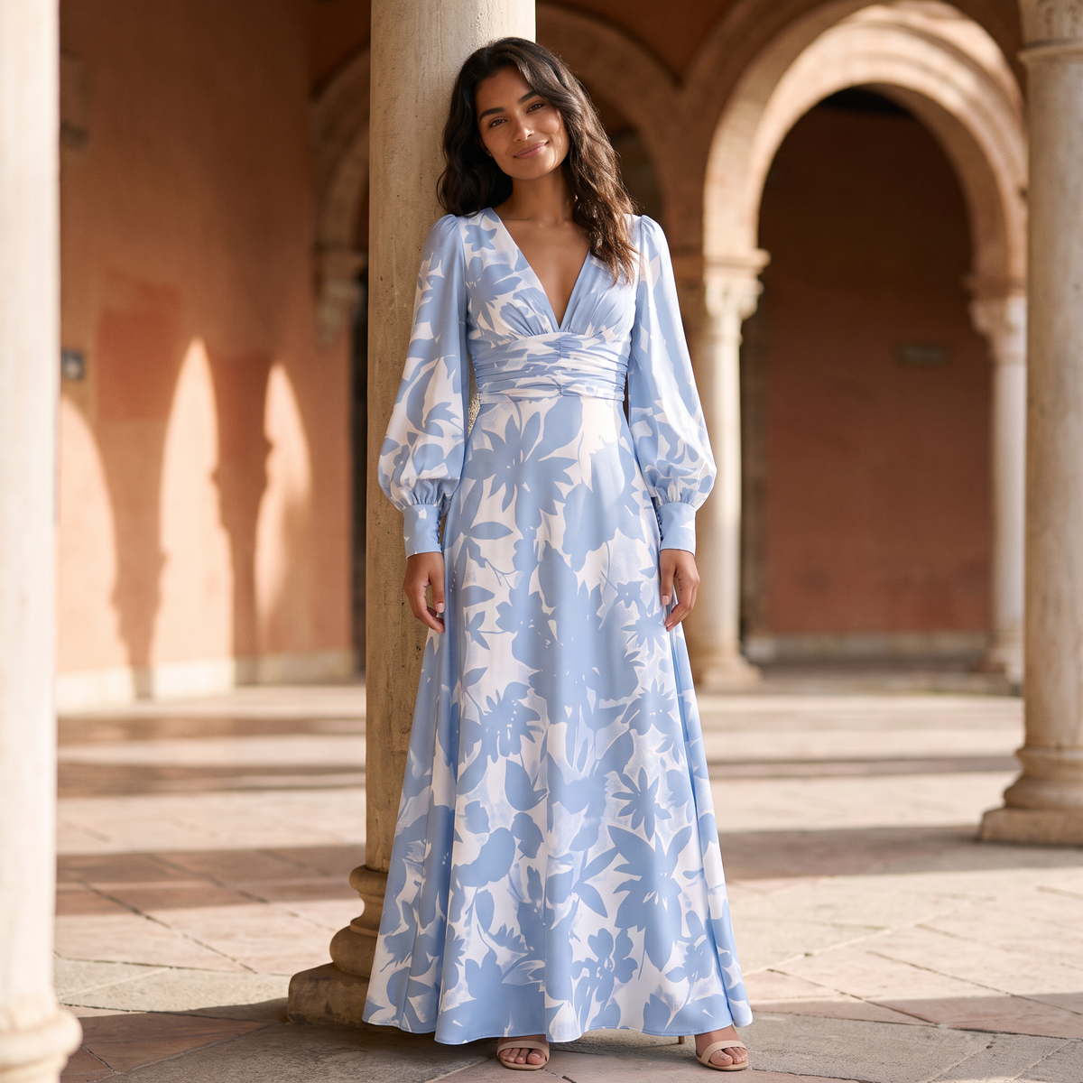 Mujer con vestido largo estampado azul claro de manga abullonada en una plaza soleada