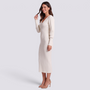 Mujer con vestido midi de punto canalé ajustado en blanco, vista lateral