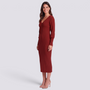 Mujer con vestido midi de punto canalé ajustado en rojo, vista lateral