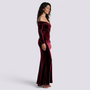 Essyro burgundy velvet mermaid evening gown with Bardot neckline and long sleeves worn by a smiling model
